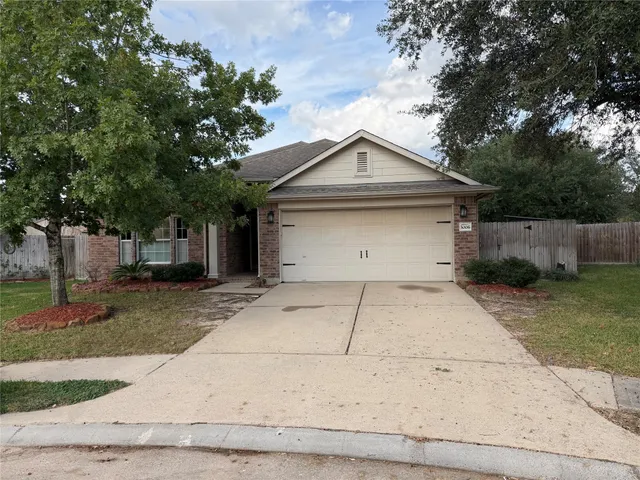 a front view of house with garage and trees
