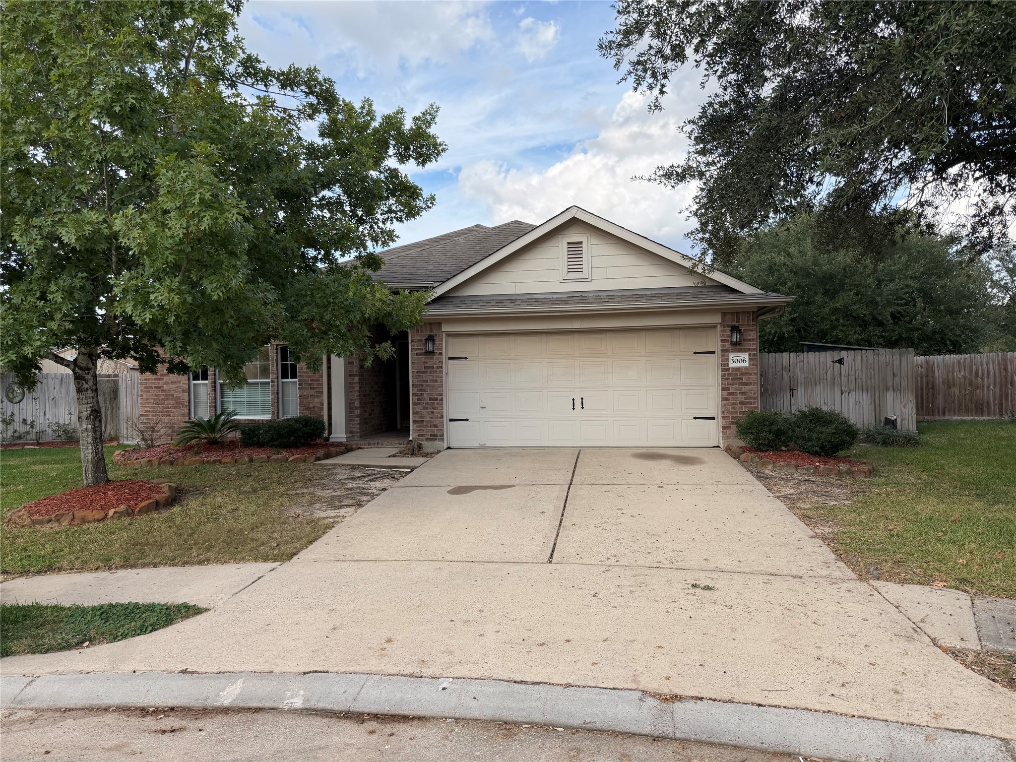 a front view of house with garage and trees
