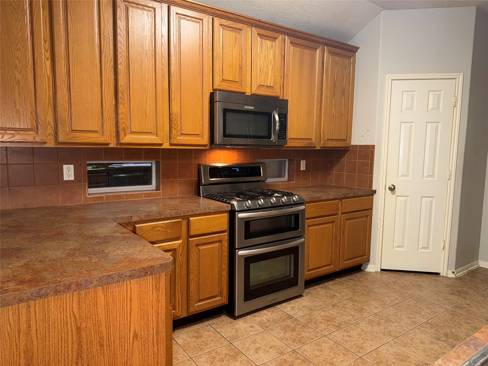 3006 Spring Fair Court Spring, TX 77388 - Photo 4 of 18 a kitchen with stainless steel appliances a stove and a microwave