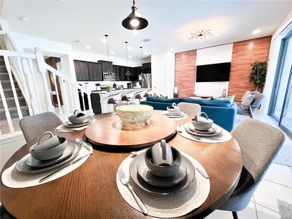 a dining room with furniture and a flat screen tv
