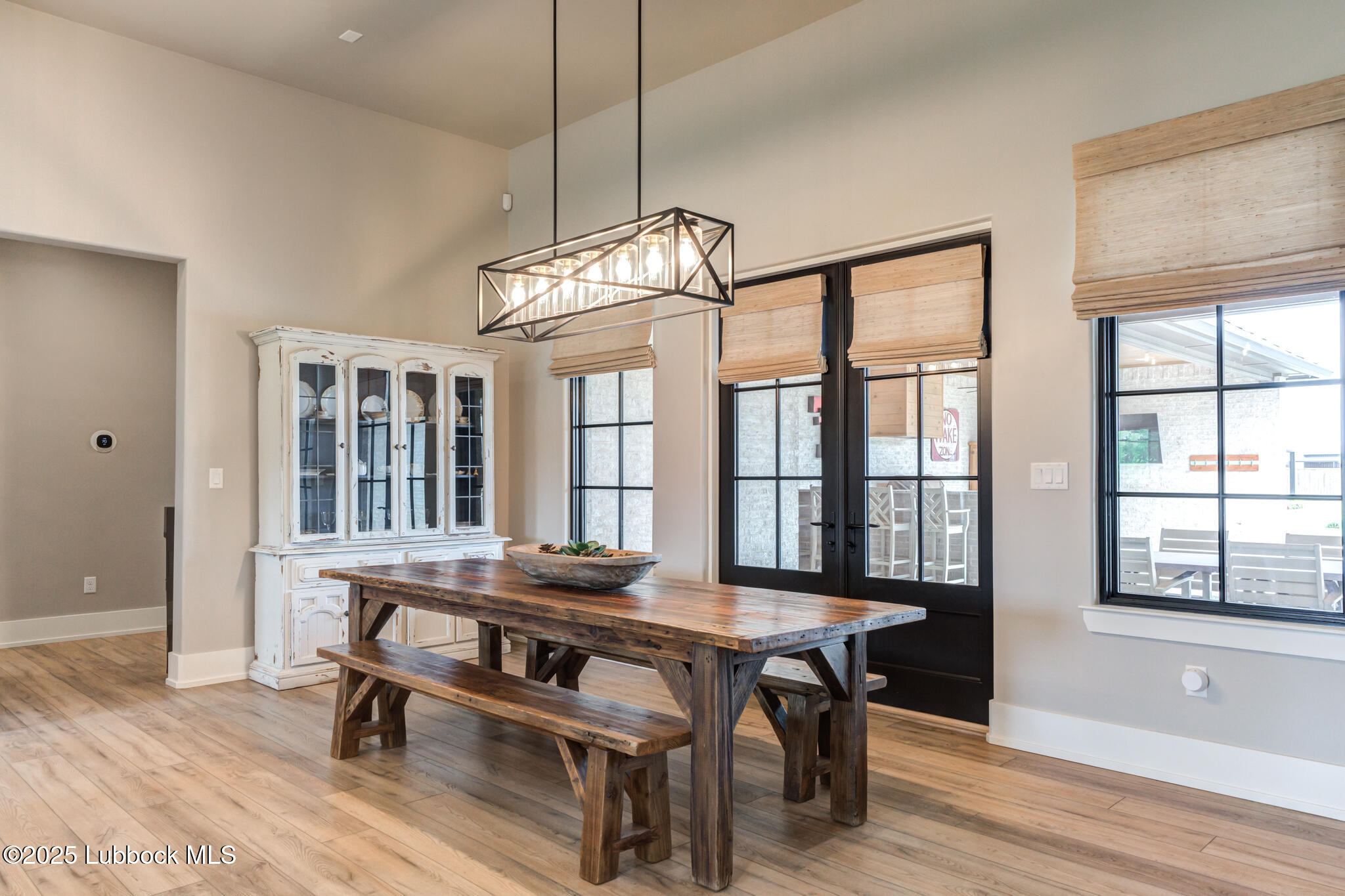 5004 County Road 7640 Lubbock, TX 79424 - Photo 15 of 79 a dining room with wooden floor a chandelier a wooden table and chairs