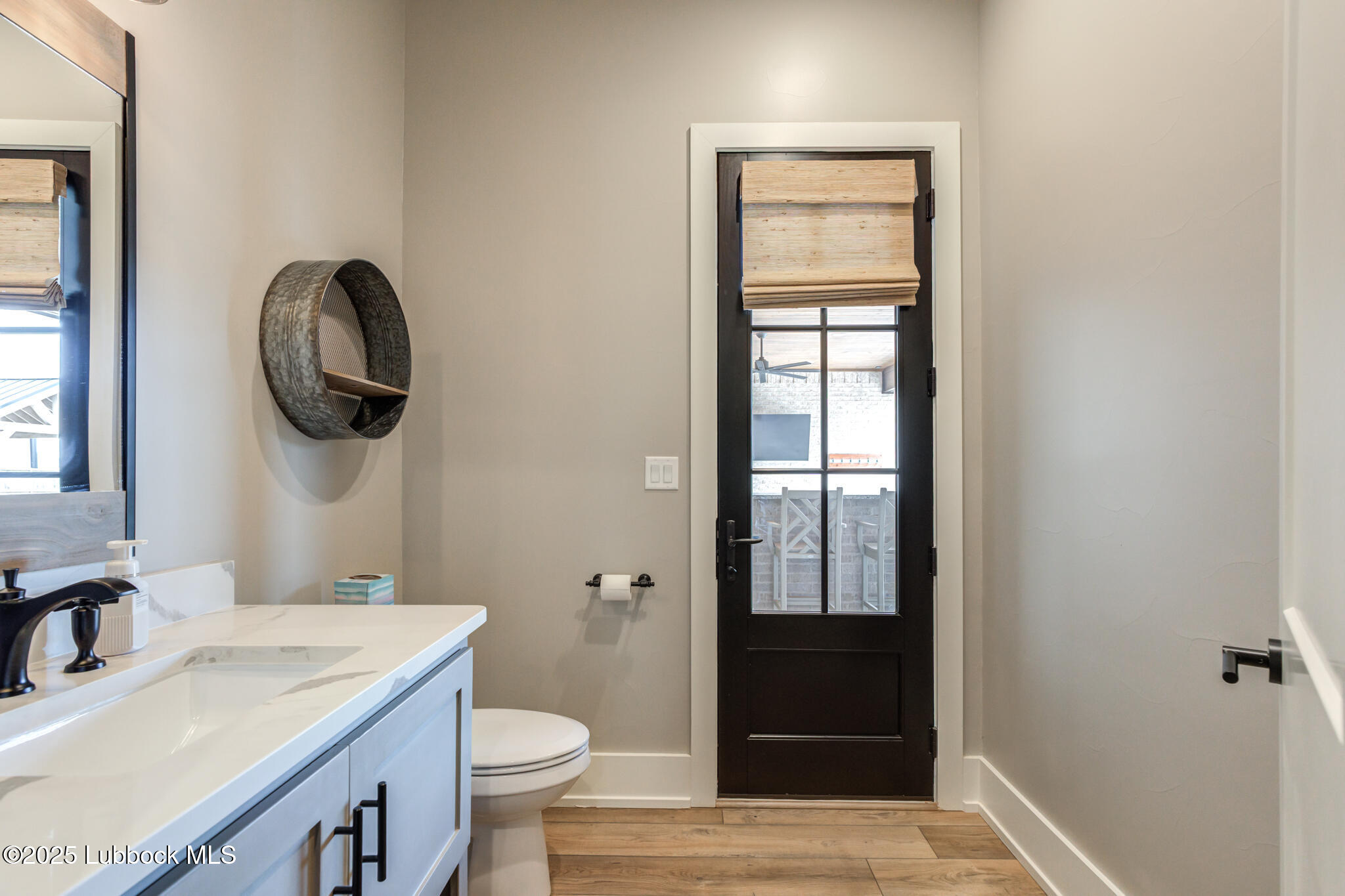 5004 County Road 7640 Lubbock, TX 79424 - Photo 28 of 79 a bathroom with a toilet a sink a vanity and mirror