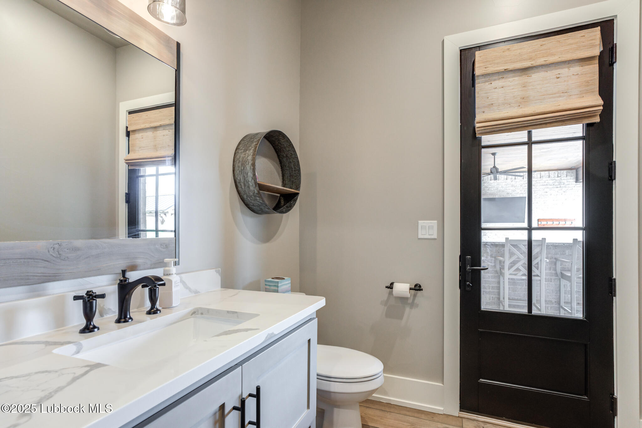 5004 County Road 7640 Lubbock, TX 79424 - Photo 29 of 79 a bathroom with a granite countertop sink toilet and mirror
