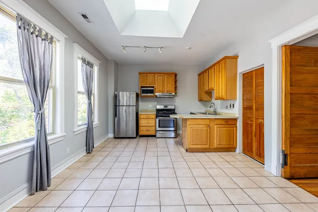 a view of kitchen with windows and refrigerator