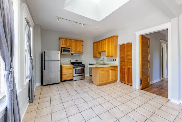 a kitchen with stainless steel appliances a refrigerator and a stove top oven