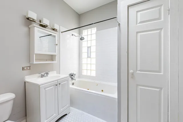 a bathroom with a sink toilet vanity and tub
