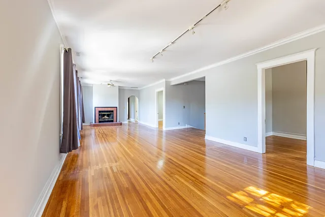 a view of empty room with wooden floor