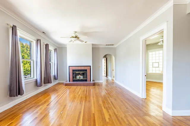 a view of an empty room with a fireplace and a window