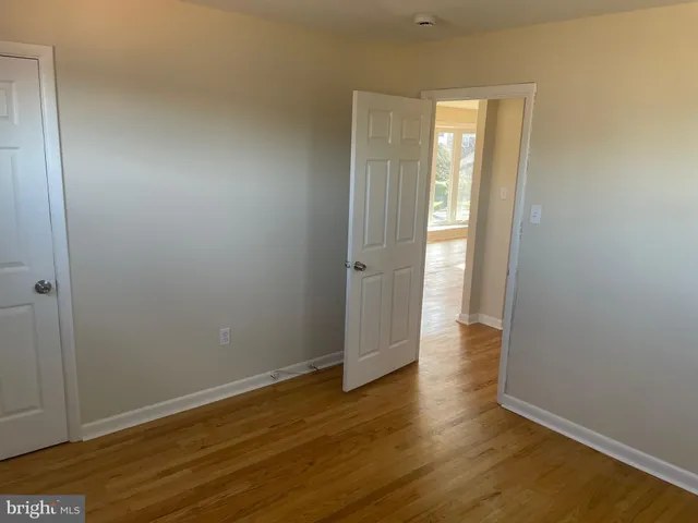 an empty room with wooden floor and closet