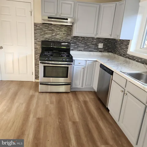 a kitchen with granite countertop a stove and a sink