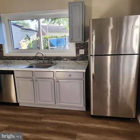 a kitchen with stainless steel appliances granite countertop a refrigerator and a sink