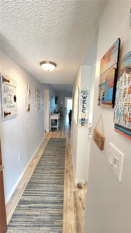 a view of a hallway with wooden floor and furniture