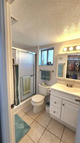 a spacious bathroom with a granite countertop sink a toilet a mirror and vanity
