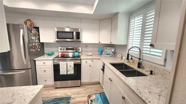a large kitchen with a stove top oven sink and cabinets