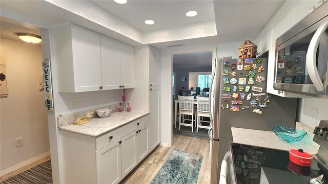 a view of a dining room with furniture a chandelier and wooden floor