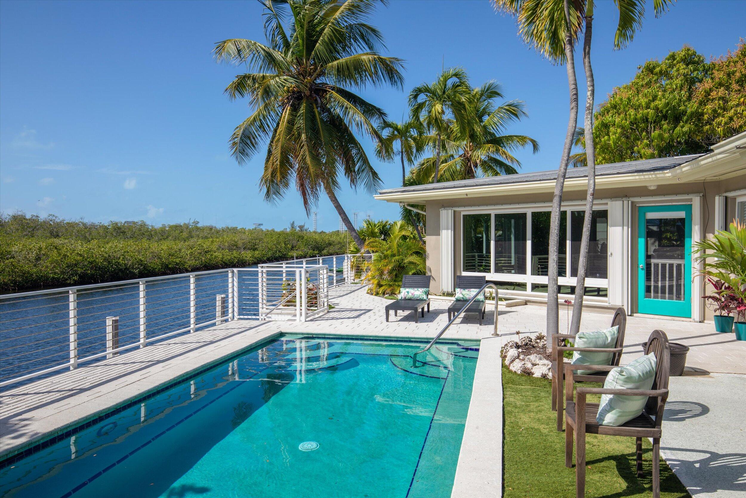 3446 Riviera Drive Key West, FL 33040 - Photo 15 of 73 a view of a house with pool and chairs