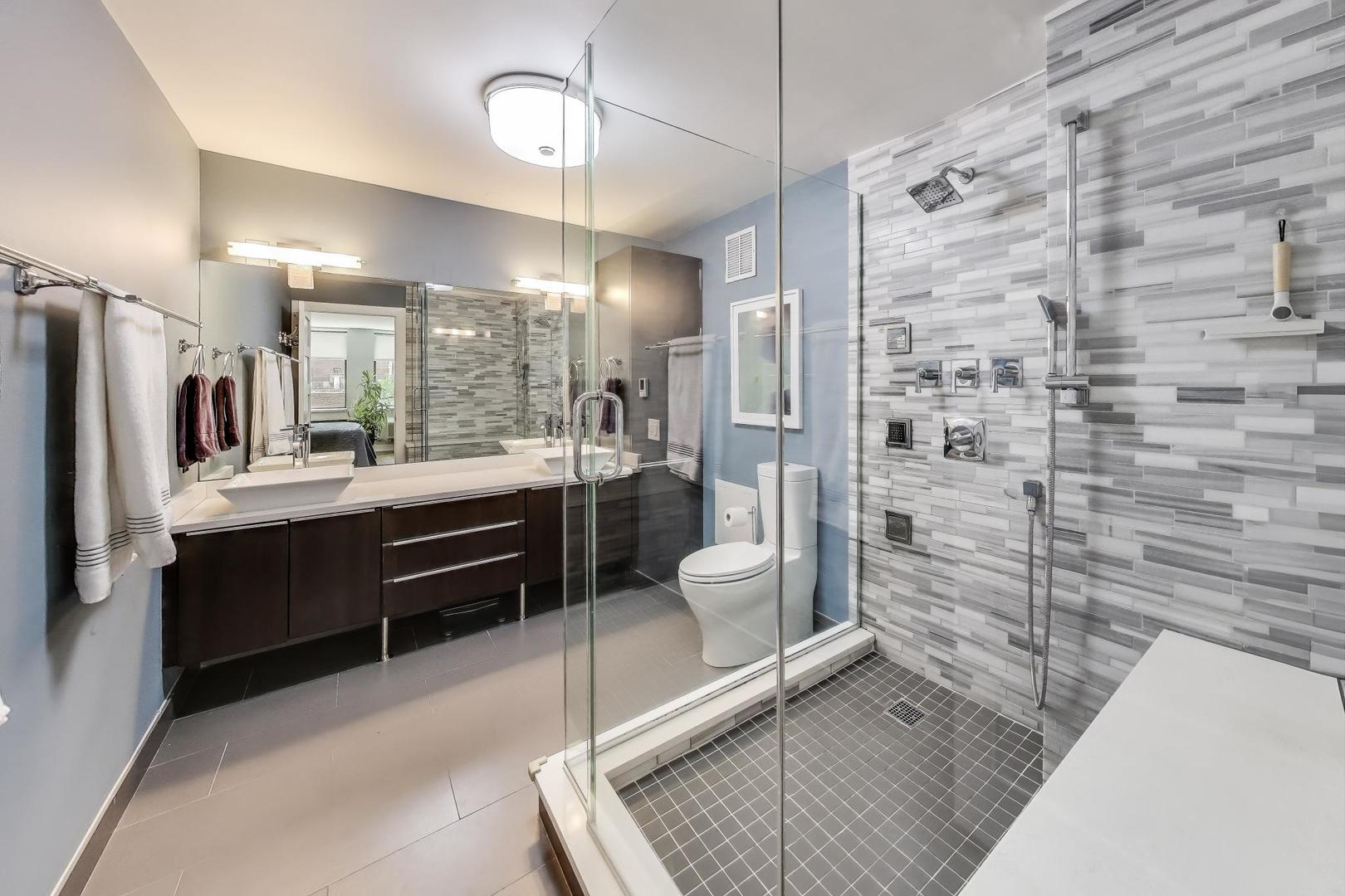 1110 North Lake Shore Drive, Unit 3N Chicago, IL 60611 - Photo 23 of 45 a bathroom with a double vanity sink a toilet a mirror and shower