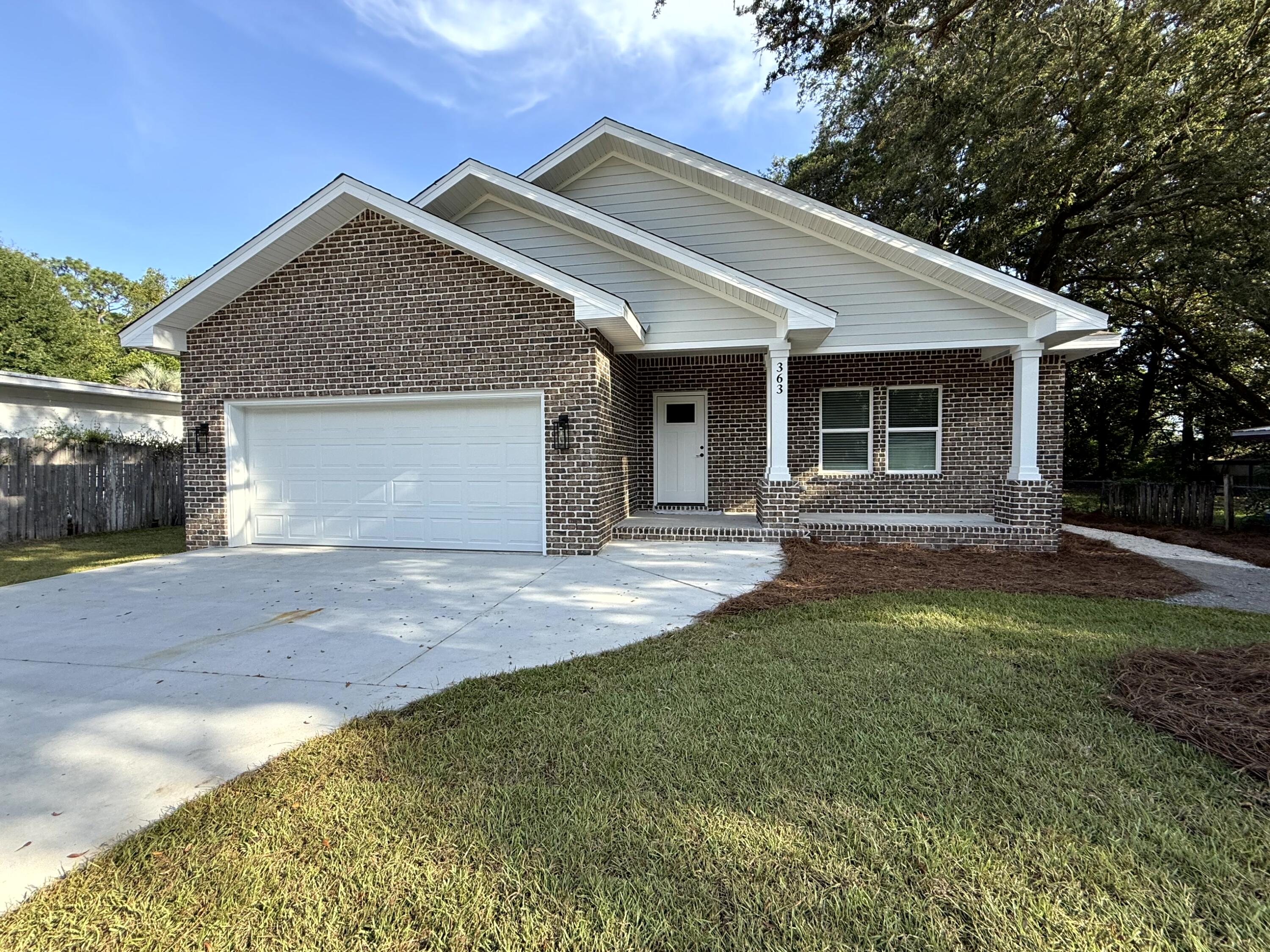 363 Washington Valparaiso, FL 32580 - Photo 1 of 35 a front view of a house with a yard and garage