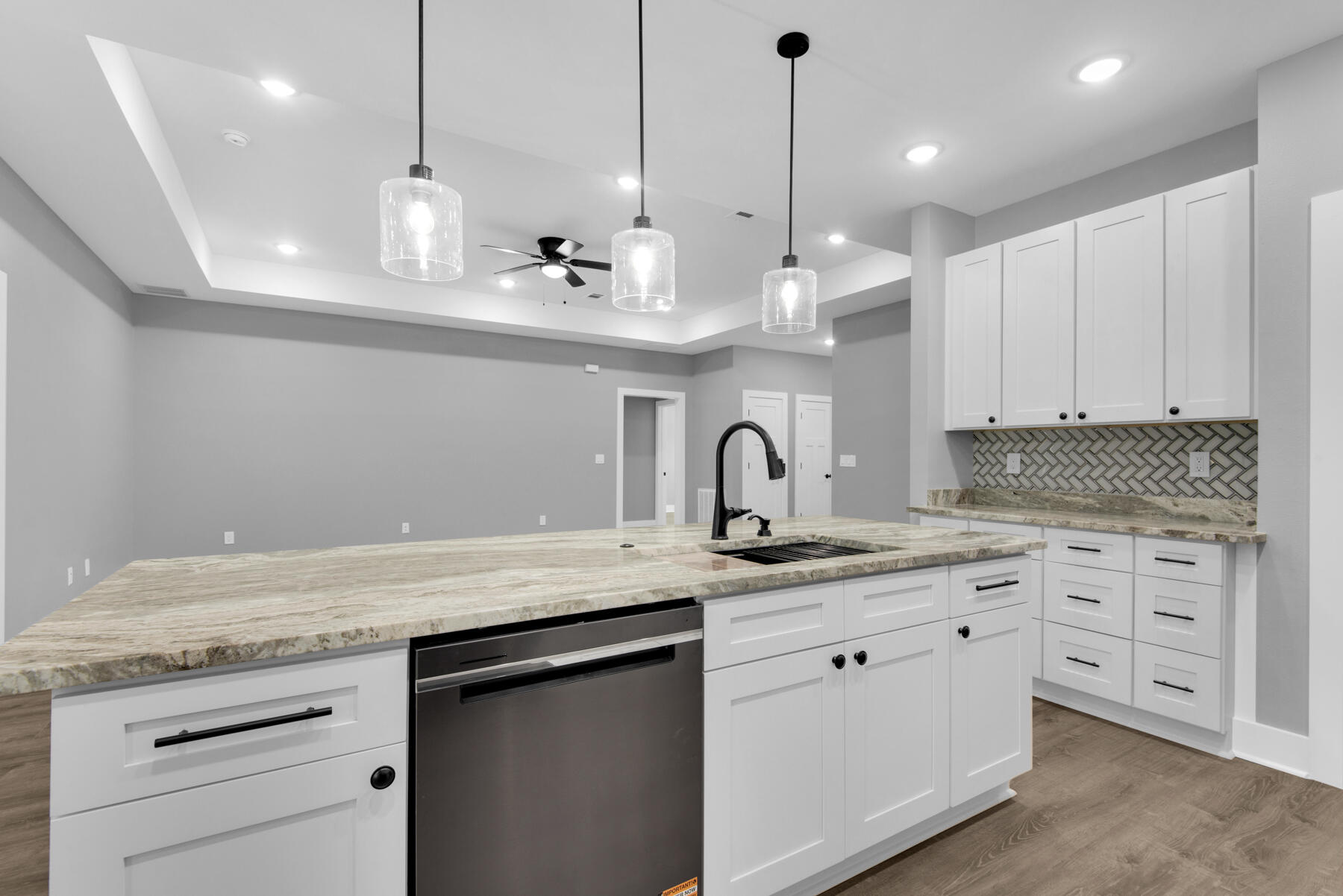 363 Washington Valparaiso, FL 32580 - Photo 15 of 35 a kitchen with stainless steel appliances granite countertop a sink a white cabinets and a wooden floor