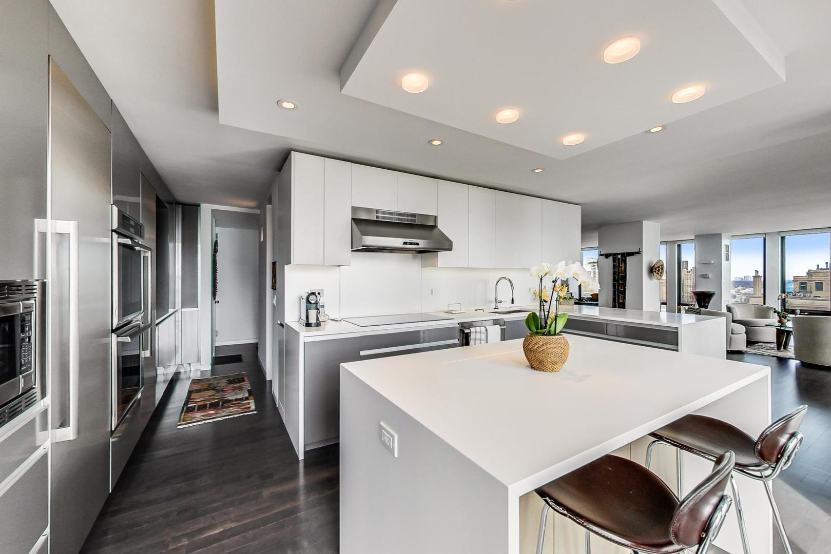 Undisclosed Address Chicago, IL 60611 - Photo 13 of 50 a kitchen with a dining table wooden floor and stainless steel appliances