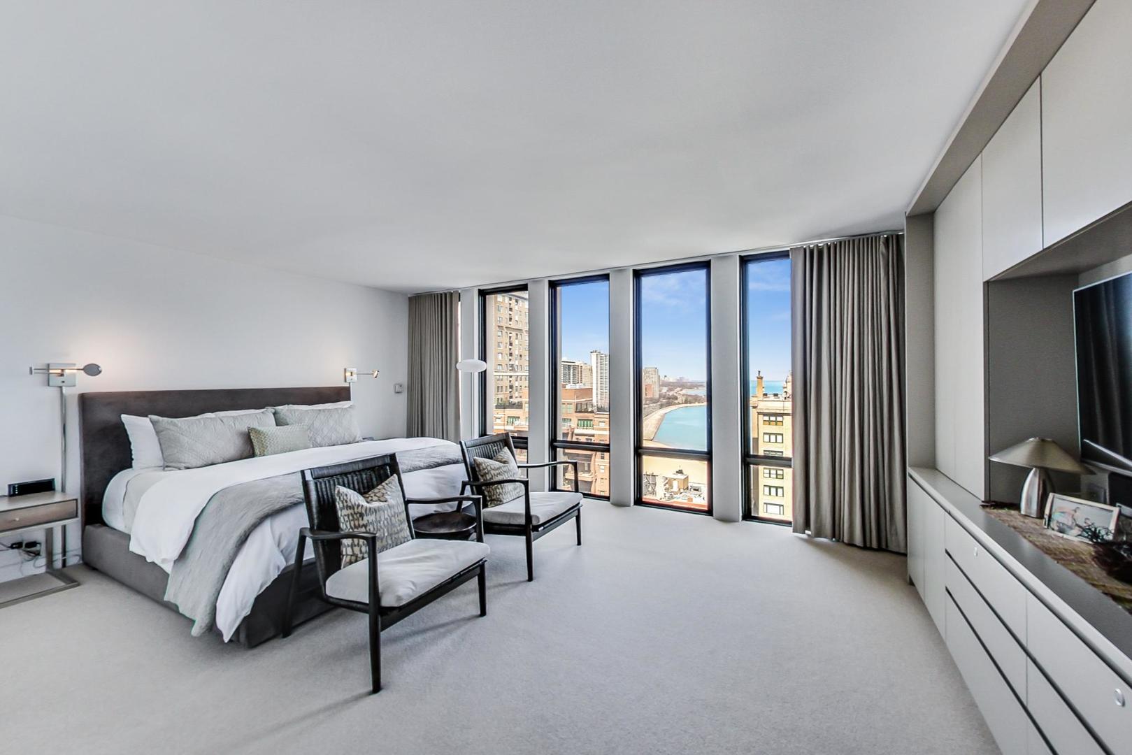 Undisclosed Address Chicago, IL 60611 - Photo 19 of 50 a spacious bedroom with a bed and a flat tv screen on a dresser