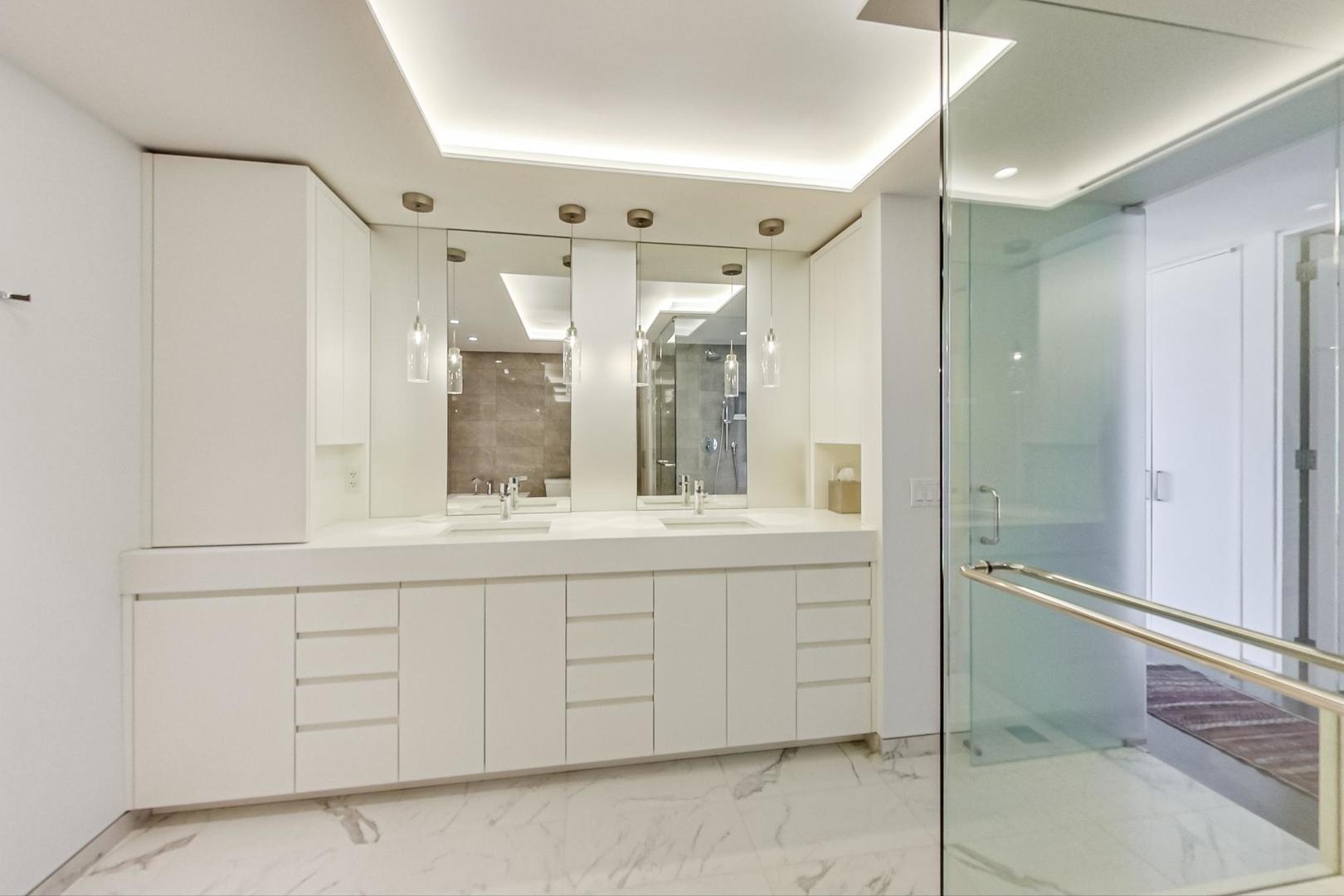 Undisclosed Address Chicago, IL 60611 - Photo 25 of 50 a bathroom with a double vanity sink and mirror