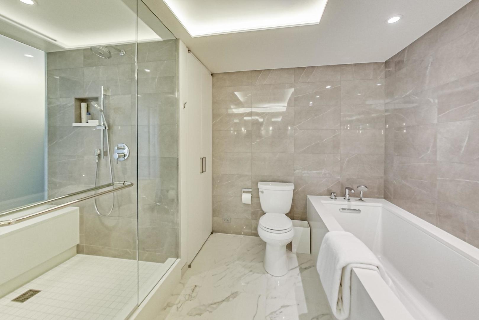 Undisclosed Address Chicago, IL 60611 - Photo 27 of 50 a bathroom with a bathtub shower sink mirror and toilet