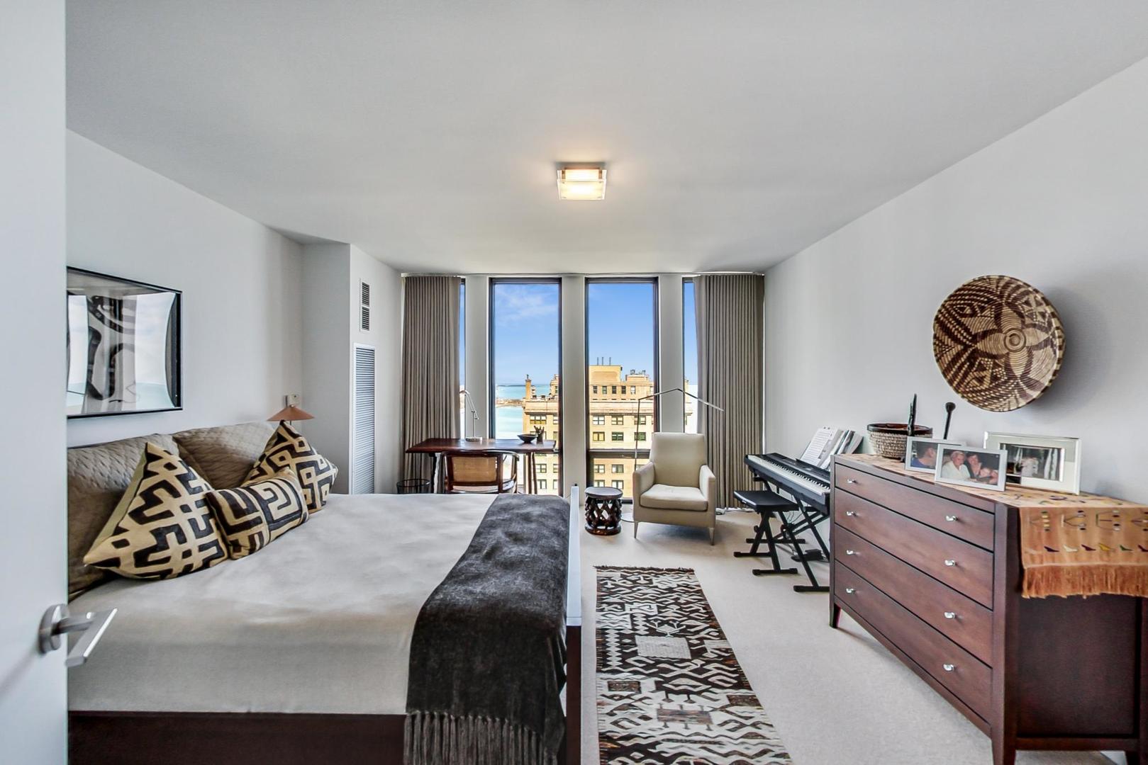 Undisclosed Address Chicago, IL 60611 - Photo 31 of 50 a bedroom with a bed large window with a dresser and chair