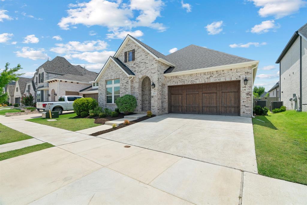 1821 Stonewall Road Argyle, TX 76226 - Photo 2 of 40 Brick exterior with a dark shingle roof and an arched entry