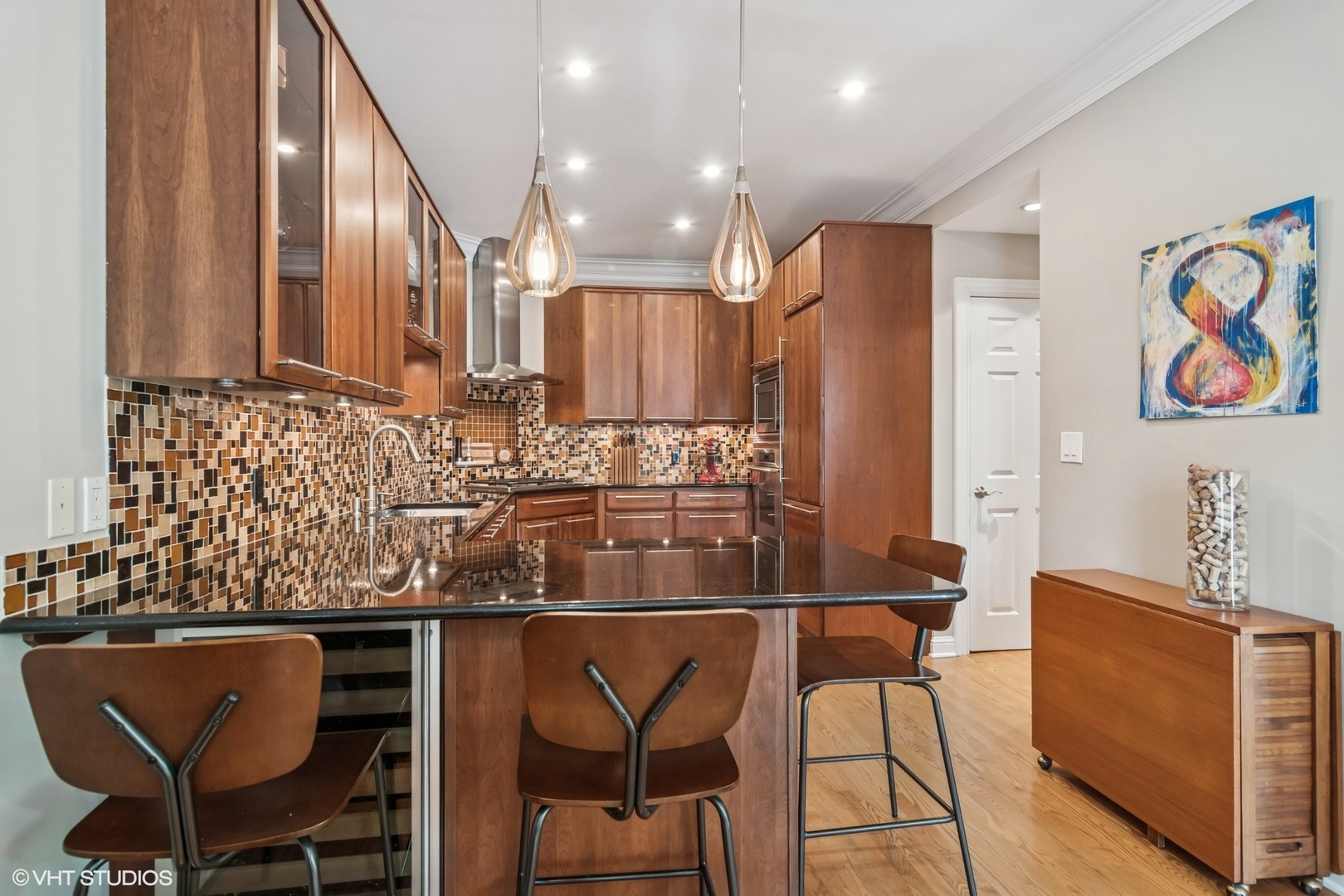 1606 North Mohawk Street, Unit B Chicago, IL 60614 - Photo 11 of 29 a kitchen with stainless steel appliances granite countertop a table chairs sink and wooden cabinets