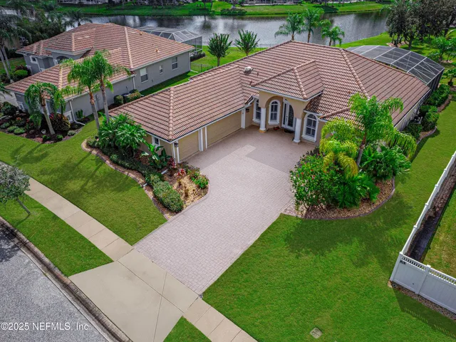 a aerial view of a house with a yard and large trees