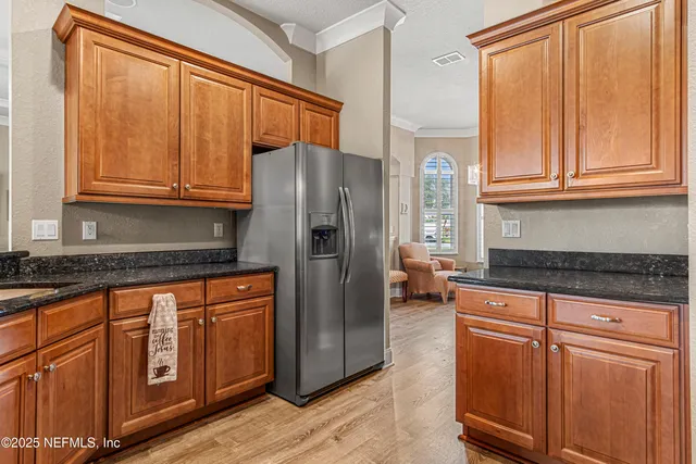 a kitchen with stainless steel appliances granite countertop a refrigerator and cabinets
