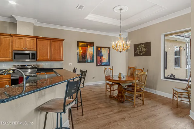 a dining room with furniture a chandelier and window