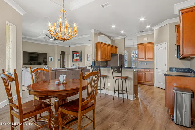 a view of a dining room with furniture a chandelier and wooden floor