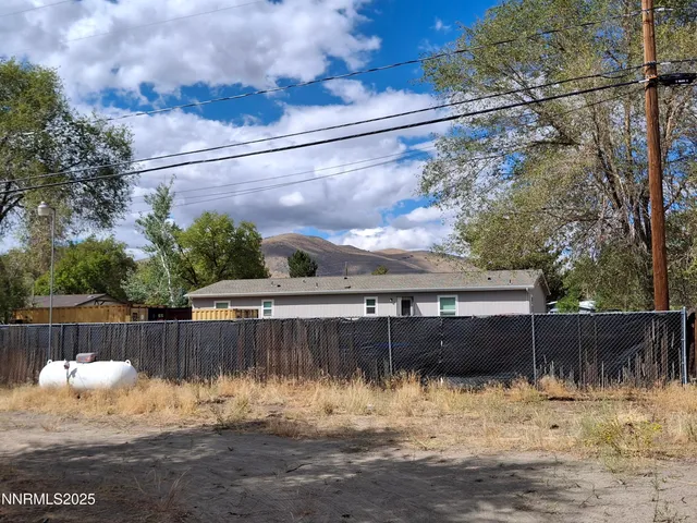 a view of a yard with wooden fence