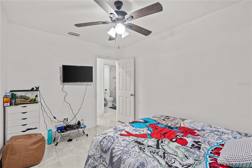13002 East Wheeler Road Dover, FL 33527 - Photo 13 of 22 a bedroom with a bed and a flat tv screen on dresser