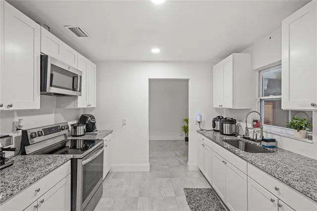 a kitchen with stainless steel appliances granite countertop a sink stove and cabinets