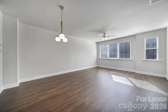 a view of a room with wooden floor and windows