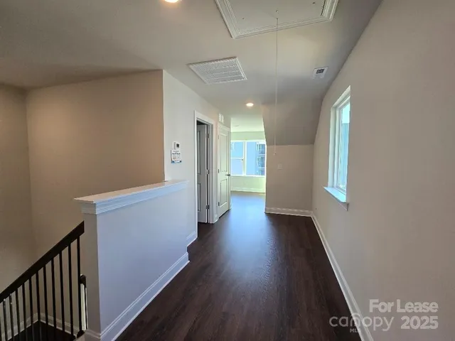 a view of hallway with stairs and wooden floor
