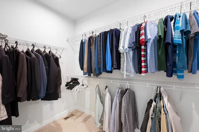 a bedroom with a bed a chair and a large window