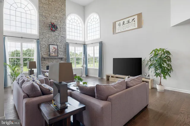 a living room with furniture a large window and a flat screen tv
