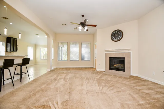 a view of an empty room with a fireplace and a window
