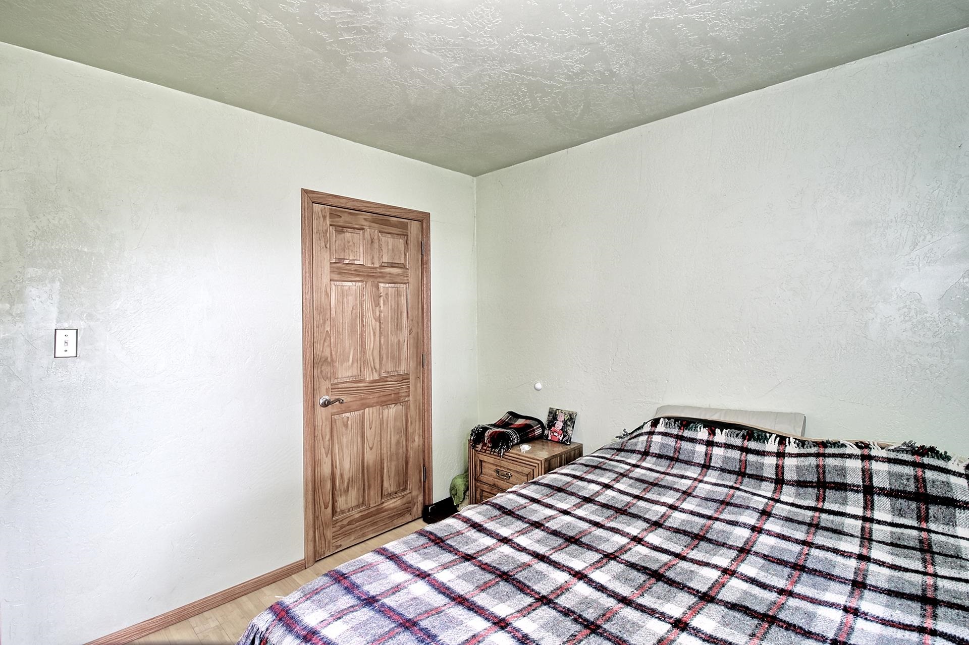 990 T Road Mack, CO 81525 - Photo 18 of 42 a bedroom with a bed and wooden floor
