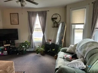 a living room with furniture a window and a flat screen tv