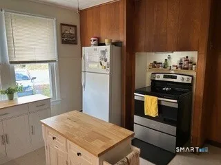 a kitchen with a refrigerator and a stove top oven