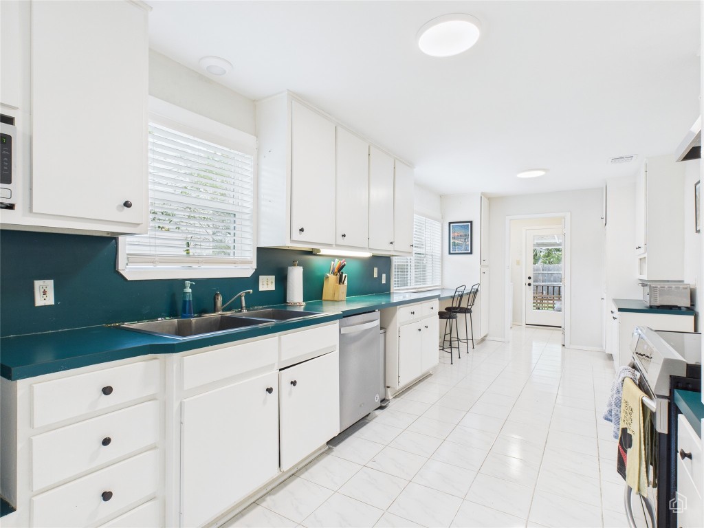 1404 Lance Way Austin, TX 78758 - Photo 14 of 29 a kitchen with granite countertop white cabinets and white appliances