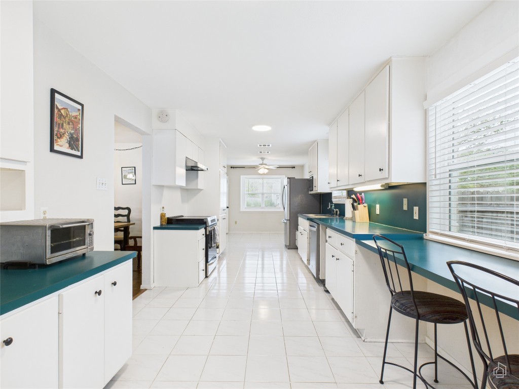 1404 Lance Way Austin, TX 78758 - Photo 15 of 29 a large kitchen with stainless steel appliances lots of counter top space cabinets and flat screen tv