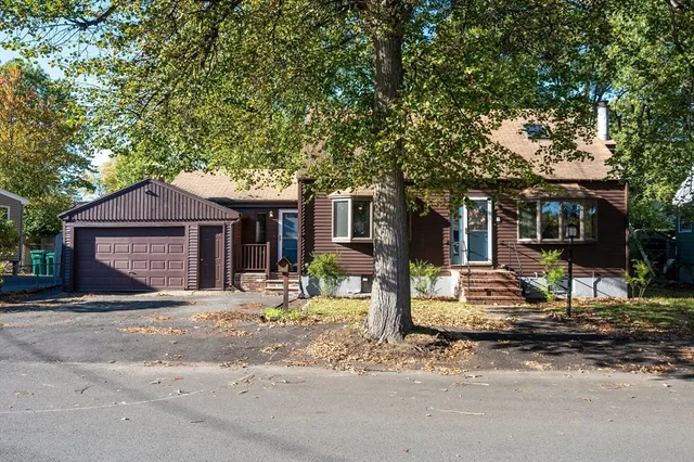 a front view of a house with a tree