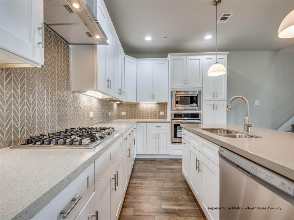 a kitchen with kitchen island white cabinets stainless steel appliances a sink and a counter top space