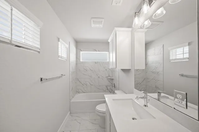 a bathroom with a bathtub a sink a toilet and a shower